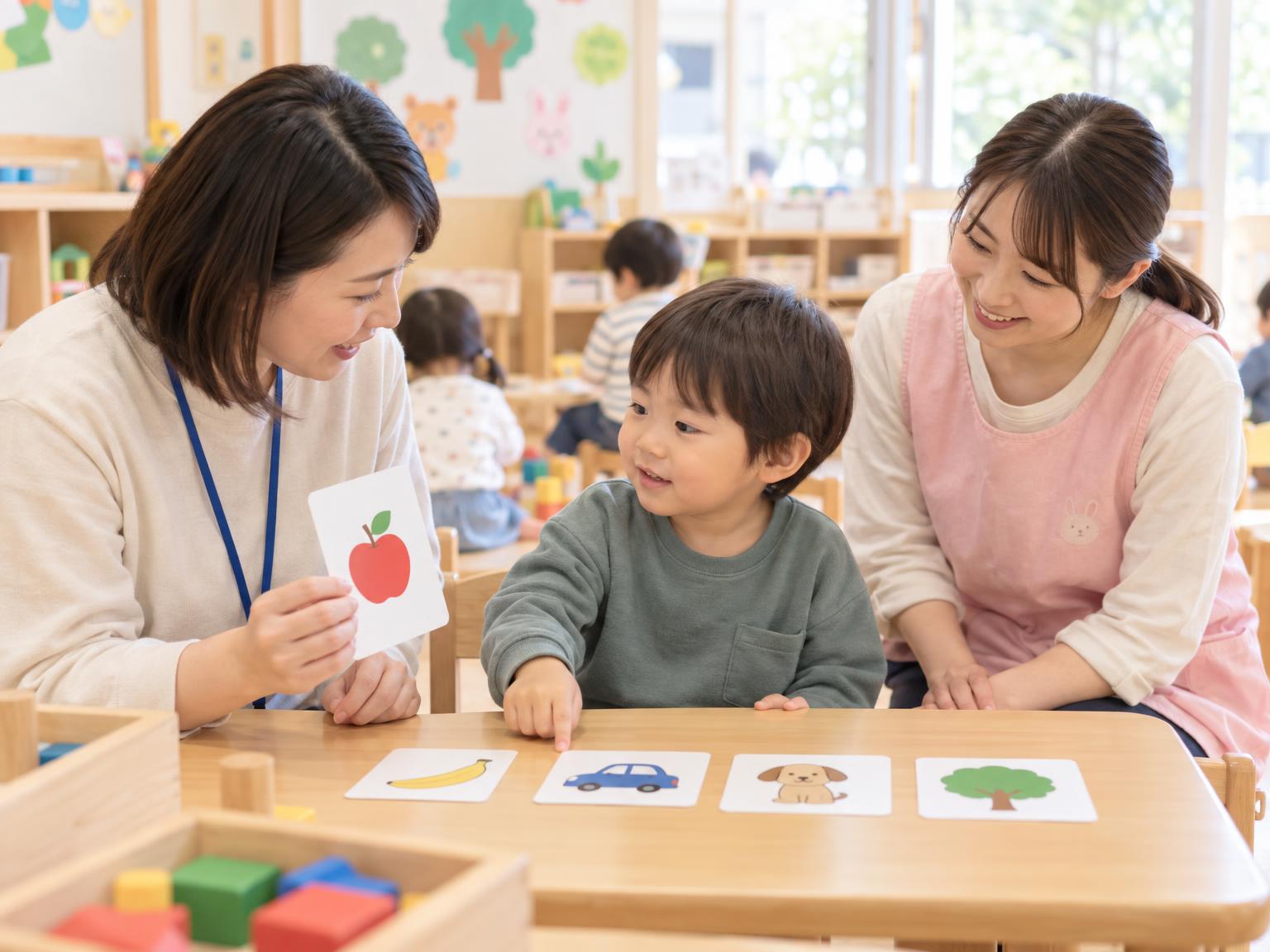 保育所等訪問支援の場面：支援員が保育園で子どもに絵カードを使って関わっている