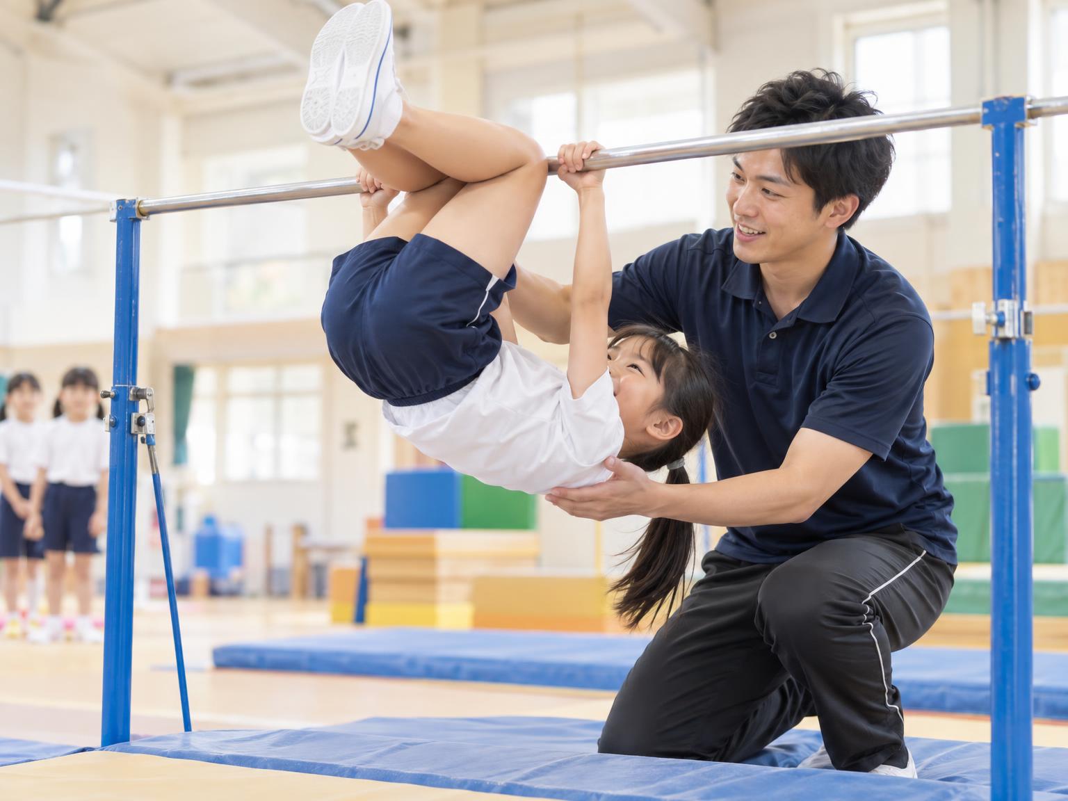 小学生が鉄棒で逆上がりの練習をしている様子