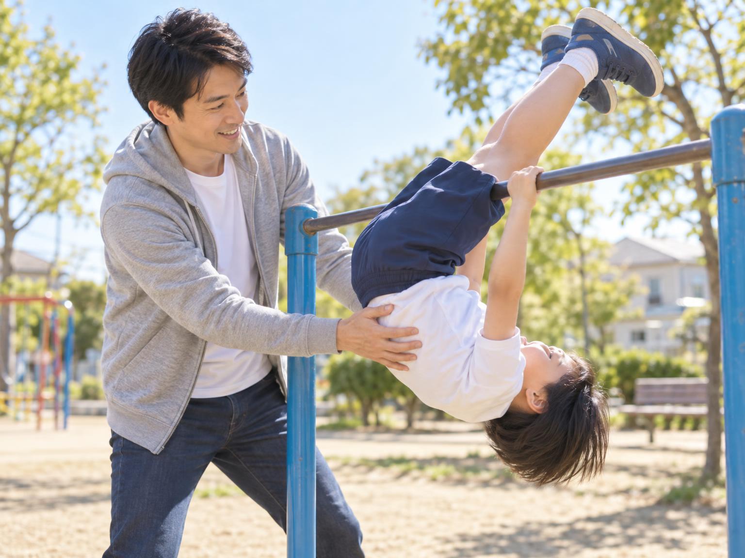 親が補助しながら子どもが鉄棒で逆上がりを練習している様子