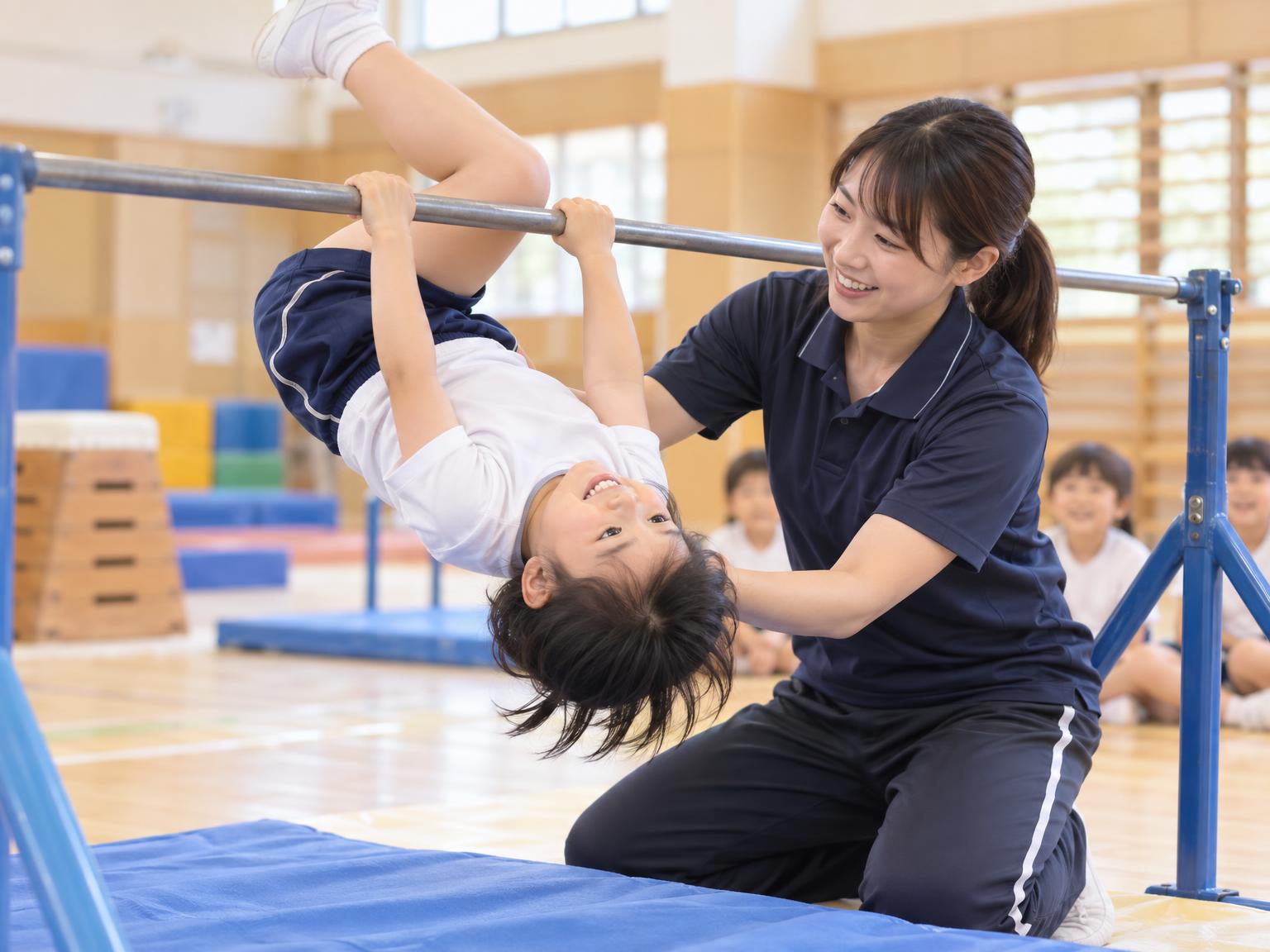 指導者に補助してもらいながら鉄棒で逆上がりを練習する子ども