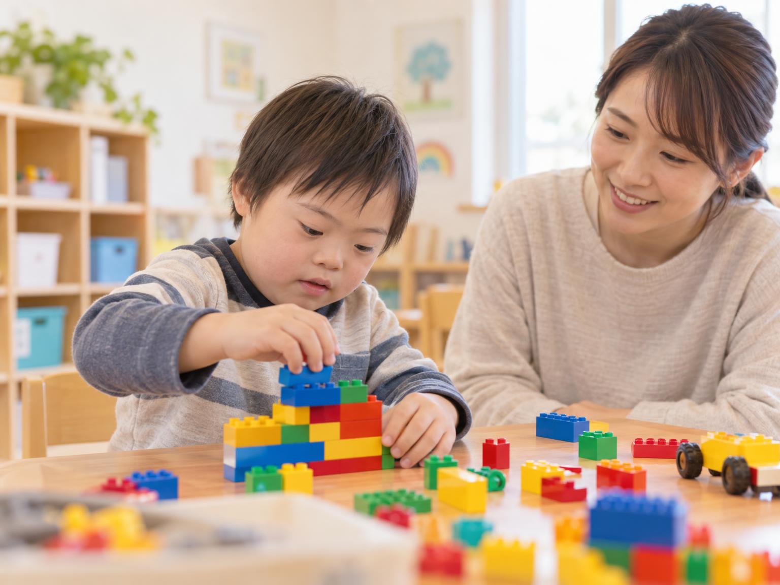 少人数の教室でレゴブロックに集中して取り組む子どもと講師