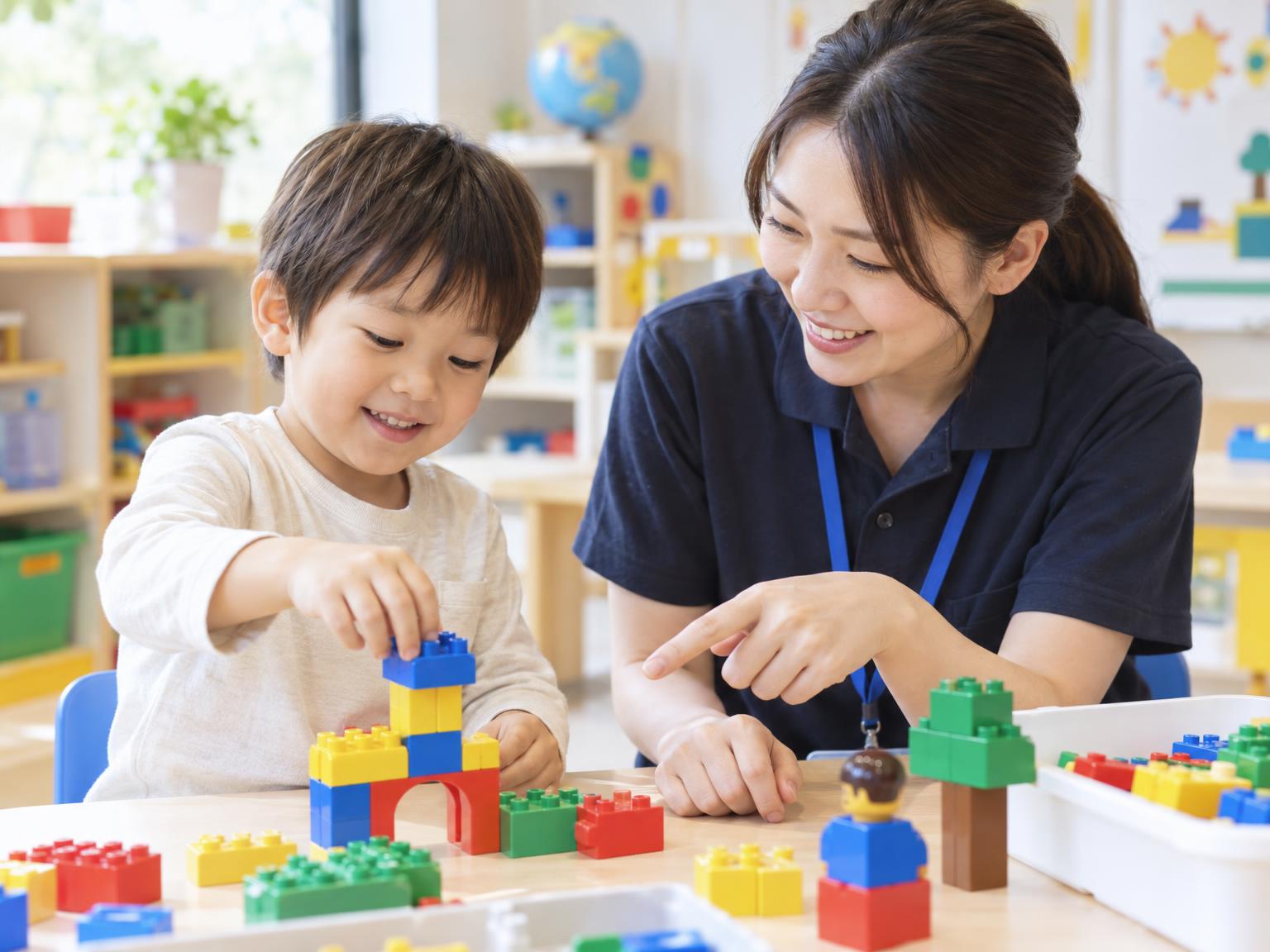 幼児がレゴデュプロを使って講師と一緒にブロックを組み立てている体験授業の様子