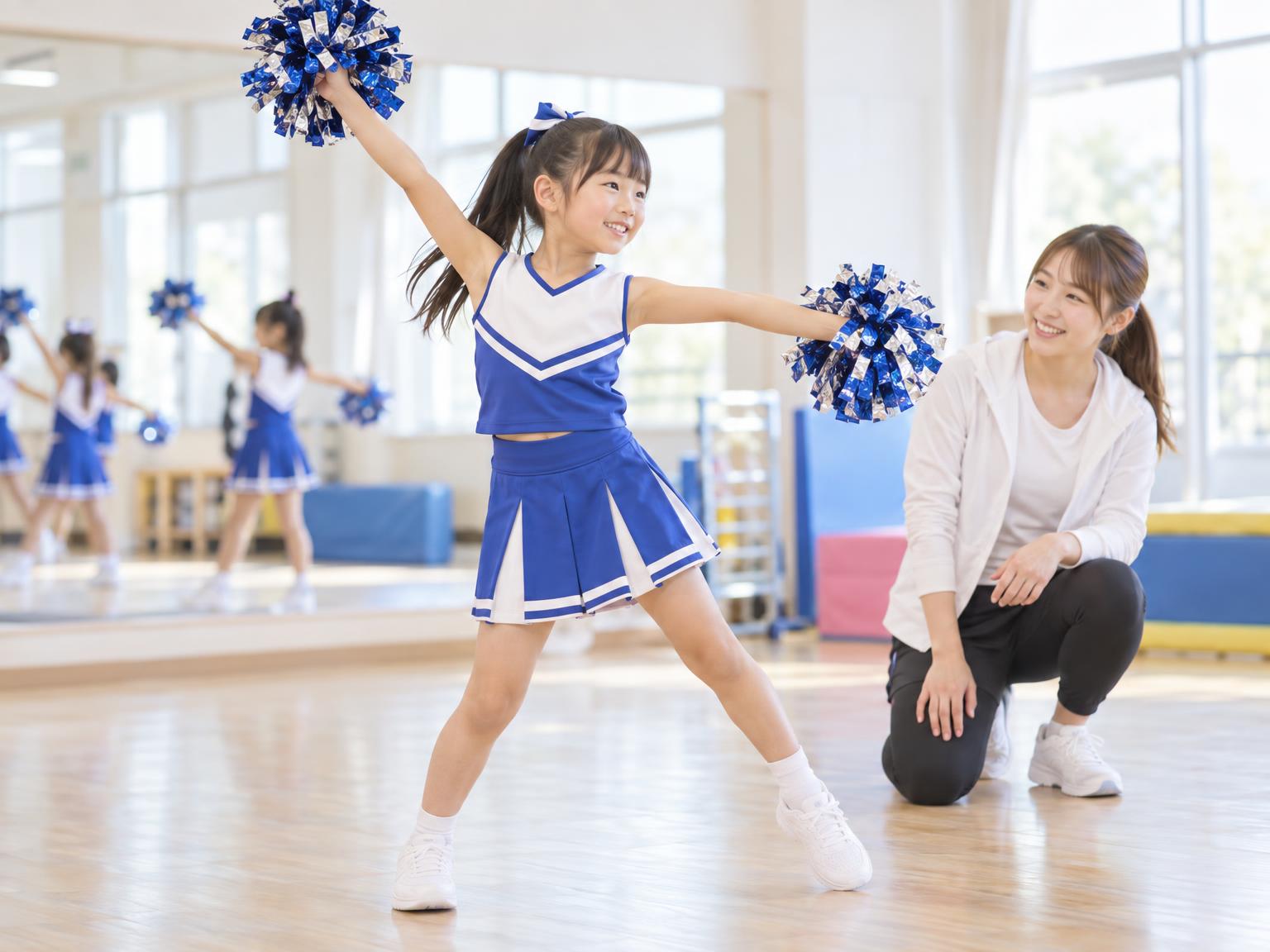 チアダンスの練習をする小学生の女の子とコーチ