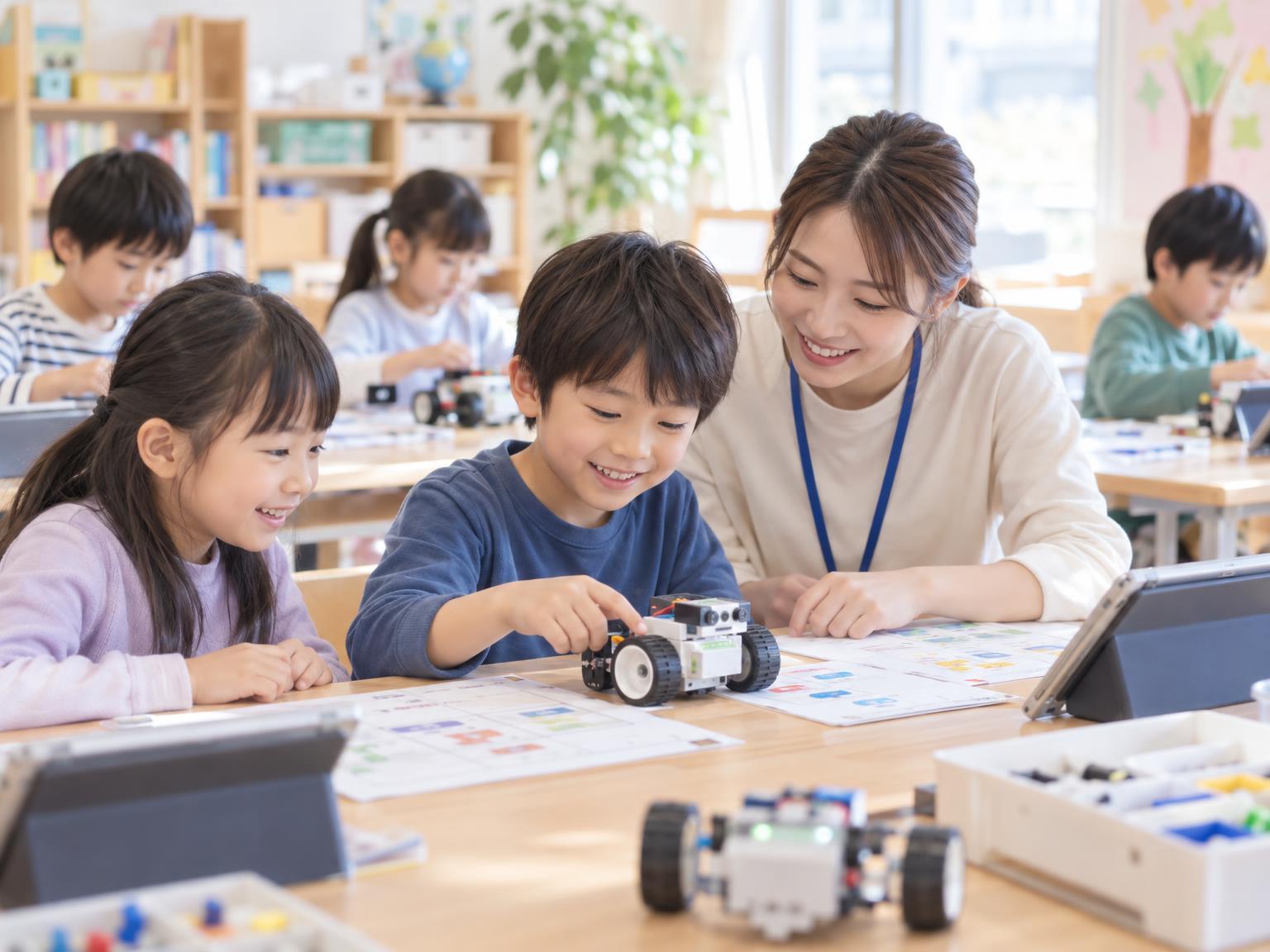 学童保育でロボット・プログラミングに取り組む子どもたちと講師