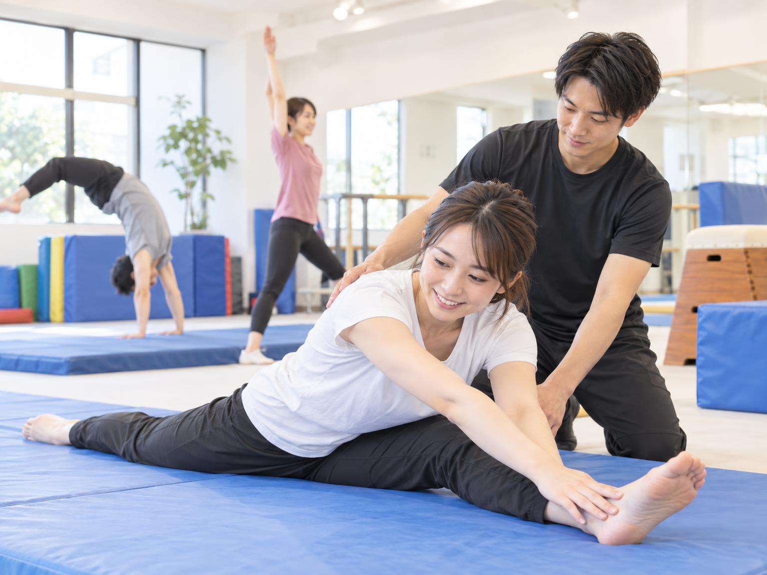 大人がアクロバット教室でマンツーマン指導を受けている様子