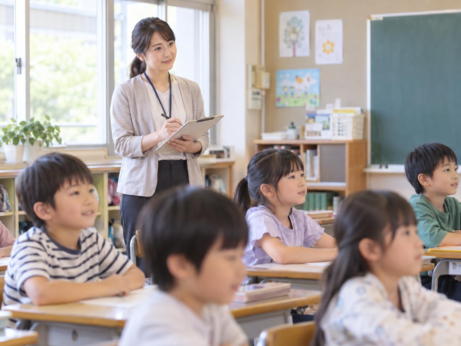 保育所等訪問支援の支援員が教室で子どもの集団場面を観察している様子